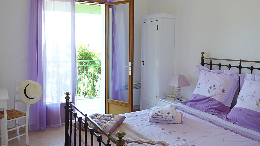 Lavande bedroom opening onto a balcony with sea views