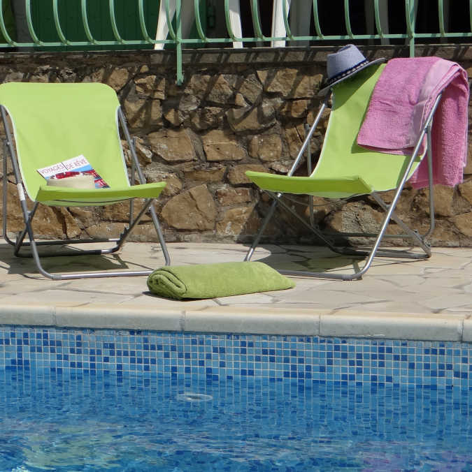 Chaises longues au bord de la piscine privée et sécurisée